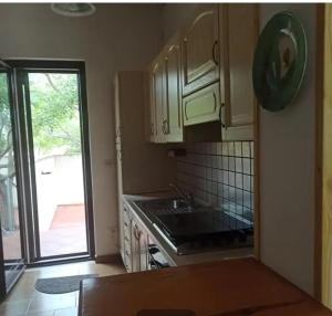 a kitchen with white cabinets and a sink and a window at Villa tra le dune di Campomarino in Campomarino