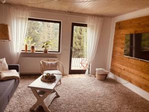 a living room with a couch and a table and windows at Rheingaulodge -Ihre Auszeit am Rheinsteig in Oestrich-Winkel