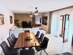 a living room with a wooden table and chairs at Bleu Fontaine in Kékkút