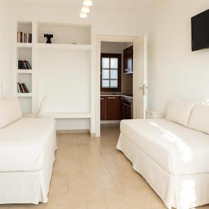 two beds in a white room with a kitchen at Enosis apartments in Agia Anna , Apartment Argo in Agia Anna Naxos