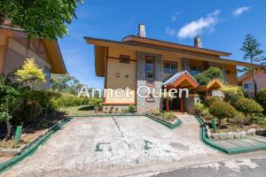 Una casa con un letrero que dice "Impulsado por estadounidenses". en 4 Bedroom Cabin in Camp John Hay, en Baguio