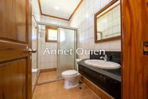 Un baño con inodoro, lavabo y espejo. en 4 Bedroom Cabin in Camp John Hay, en Baguio 33 fotos más