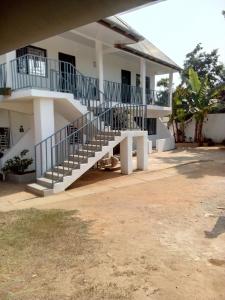 a white building with stairs in front of it at Airport Lodge Lungi in Lungi
