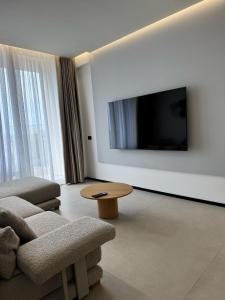 a living room with a tv and a couch and a table at Aquazul, Green Coast in Palasë +3 photos