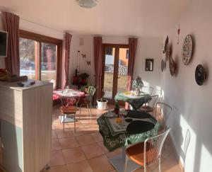 a living room with tables and chairs in a room at Relais Tesino in Castello Tesino