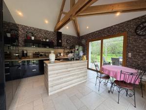 a kitchen with a pink table and a dining room at La Parenthèse Verte - 8pers - Piscine - Rêve au Mans in Roézé-sur-Sarthe