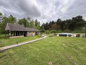 a large yard with a stone house and a grass field at La Parenthèse Verte - 8pers - Piscine - Rêve au Mans in Roézé-sur-Sarthe