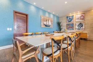 a dining room with a large white table and chairs at Mansão Oceano, Luxo em Porto Mirim by Carpediem in Jacumã
