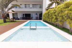 a swimming pool in front of a villa at Mansão Oceano, Luxo em Porto Mirim by Carpediem in Jacumã