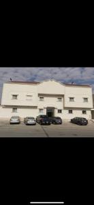 Un gran edificio blanco con coches aparcados delante. en Luxury Apartment in Riyadh, en Riad