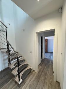 a staircase in a room with white walls and wooden floors at Casa Zia Amneris in Torrita di Siena