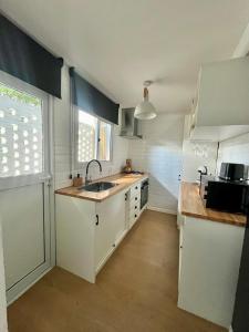 a kitchen with white cabinets and a sink and a window at Puerta Azul in Punta del Este