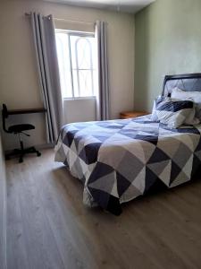 ein Schlafzimmer mit einem Bett, einem Fenster und einem Stuhl in der Unterkunft Casa Portales Ciudad Juarez in Zaragoza