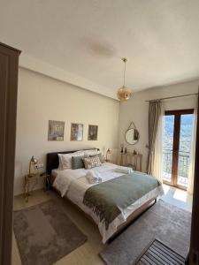 a bedroom with a large bed and a large window at Avra Metsovou in Metsovo