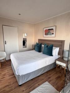 a bedroom with a large white bed with blue pillows at Olives by Agnes 33 in Hartbeespoort +26 photos