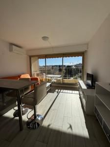 罗克布吕讷-卡普马丹Studio ideal pour les vacances的带桌子和大窗户的客厅