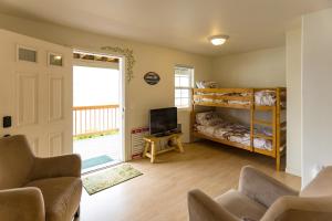 a living room with two bunk beds and a tv at Wapato Lake Waterfront Retreat in Manson