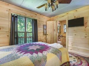 - une chambre avec un lit et une télévision dans l'établissement Bearly Hidden: Peaceful Creekside Escape with Hot Tub, à Gatlinburg