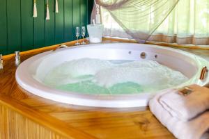 a bath tub filled with water on top of a wooden table at Cabana Lake Side Refúgio Charmoso no Vale Europeu in Benedito Novo +66 photos