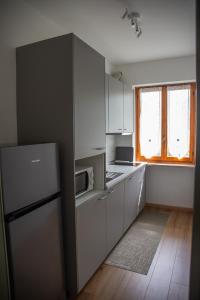 a kitchen with white cabinets and a refrigerator and a window at Cà d'Nonu in Chiusa di Pesio