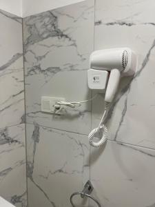 a white hairdryer on a wall in a bathroom at Gabriela Studio Central by Gabriela Apartamente in Satu Mare