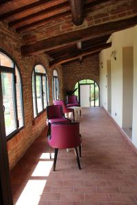 rząd czerwonych krzeseł w pokoju z oknami w obiekcie Nuovo Etruria Resort w mieście Montepulciano