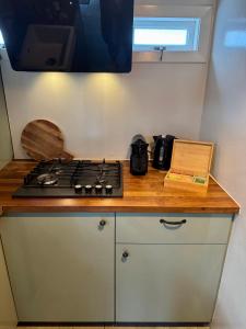 encimera de cocina con fogones y ventana en Wanderlust - Vlakbij strand - Omheinde privétuin, en Noordwijk aan Zee