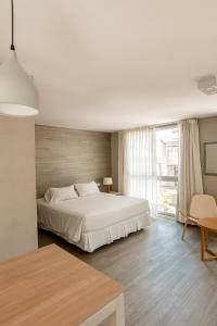 a bedroom with a white bed and a large window at Smart Hotel Montevideo in Montevideo