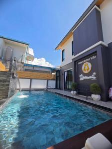 a swimming pool in front of a building at Queen Ma Pool villa in Ban Nong Bua