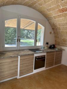 a kitchen with two windows and a counter at La Limonaia in Veglie