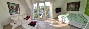 a bedroom with a bed and a couch and a window at Schönste Lage am Rhein in unmittelbarer Stadtnähe, B & B in Cologne