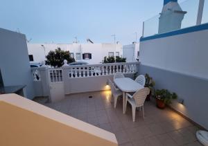 a balcony with a table and chairs on a building at Casa Yucca in Salema