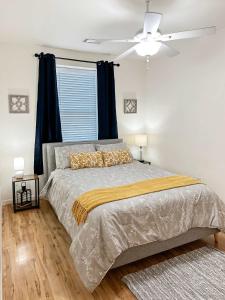 Central Downtown Stay في لا كروس: غرفة نوم بها سرير ومروحة سقف