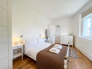 a bedroom with a bed with two towels on it at Spacious Camden Apartment D2 in London