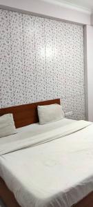 a bedroom with two beds and a wall with a white bedspread at Hotel Abhi family guest house in Lucknow +17 photos