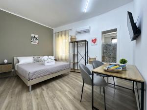 a bedroom with a bed and a table and a dining room at Tina House in Siculiana
