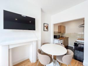 a white kitchen with a white table and chairs at Spacious Camden Apartment D2 in London +4 photos