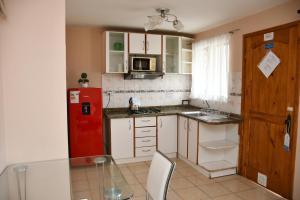 a kitchen with a red refrigerator and a table at Cabañas Rey Pacific in La Serena