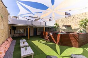 a patio with two tables and a large umbrella at Fata morgana Hostel in Beer Sheva
