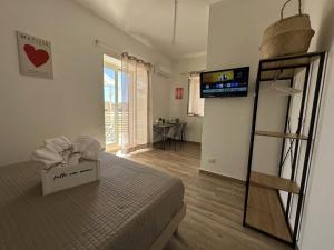 a room with a bed and a room with a television at Tina House in Siculiana