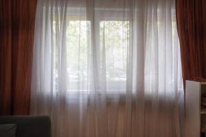ein Fenster mit weißen Vorhängen in einem Zimmer in der Unterkunft Spacious apartment Near National Arena, park in Bukarest