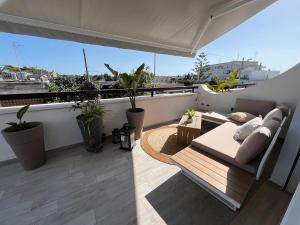 a balcony with a couch and a table and plants at Radici Mare B&B in Torre dell'Orso