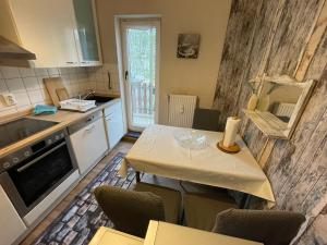 a kitchen with a table with chairs and a counter top at Gemütlich & Zentral - Familien-Oase mit Balkon,Waschmaschine, Trockner für 4 Personen in Bremerhaven