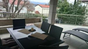 a table and chairs sitting on a balcony at Fefe Apartment with Sea view in Vantačići