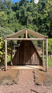 a wooden shelter with a frisbee in the air at Vale do Rio Bonito Glamping in Riozinho