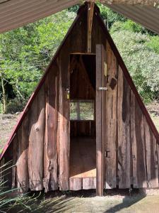 an open door of a wooden out house at Vale do Rio Bonito Glamping in Riozinho