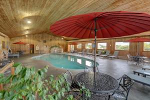 a pool with a table and a red umbrella at Misty Harbor Resort in Wells