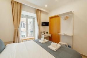 a bedroom with a large bed with two white towels at Downtown Lisbon Suites by Hosty in Lisbon +86 photos