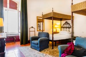 a bedroom with a four poster bed and a chair at Pousada Castelo de Estremoz in Estremoz +41 photos