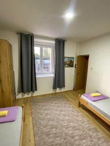ein Zimmer mit zwei Betten und einem Fenster in der Unterkunft Old Town Oasis in Podgorica